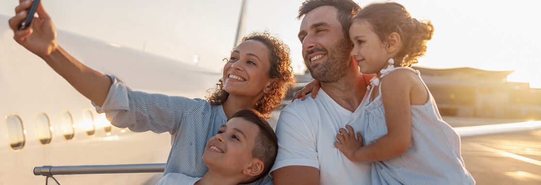 Family taking a selfie near an airplane