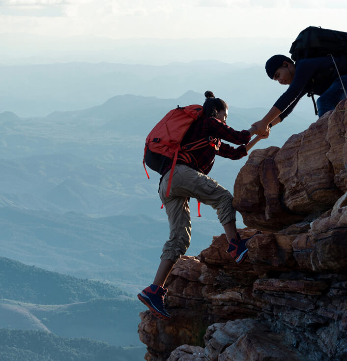 pair of people climbing cliff